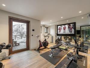 a gym with bikes and a flat screen tv at Chalet skis aux pieds avec bain nordique, 12/14 pers, chef inclus - FR-1-570-3 in Saint-Martin-de-Belleville