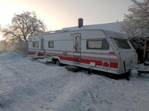 a red and white trailer parked in the snow at Tornio caravan in Tornio