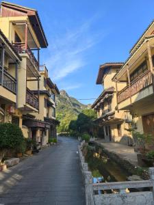 a street in a town with buildings and a canal at Cozy Mountain Retreat in Guilin