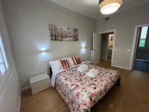 a bedroom with a bed with a floral bedspread at Appartamento Elena in Parma