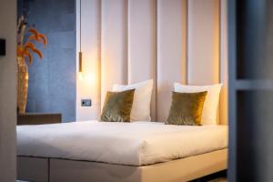 a bedroom with a bed with two pillows at Hotel Asteria in Venray