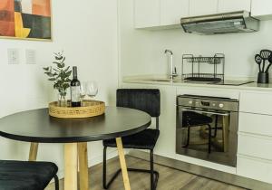 a kitchen with a table with two chairs and a stove at RentUp Suites Palmas Park Buenavista in Victoria