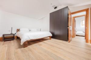 a bedroom with a bed and a wooden floor at Seaview Penthouse 2 in Alnmouth