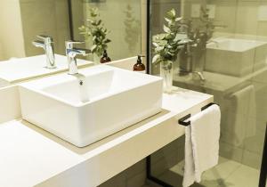 Un baño con un lavabo blanco y un espejo. en RentUp Suites Palmas Park Buenavista, en Victoria 62 fotos más