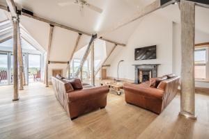 a living room with two chairs and a fireplace at Seaview Penthouse 2 in Alnmouth