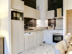 eine weiße Küche mit weißen Schränken und Geräten in der Unterkunft Appartement 4 pièces de luxe, à deux pas des pistes et commerces, avec parking et accès fitness à Courchevel - FR-1-562-35 in Courchevel