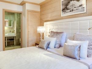 une chambre avec un lit blanc avec des oreillers dans l'établissement Appartement moderne avec WiFi et parking sous-terrain à Courchevel Village - FR-1-562-28, à Courchevel