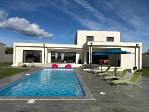 a house with a swimming pool and some chairs at Spacieuse villa standing de 220m2 à 5 minutes des plages in Aléria