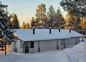 une maison avec de la neige sur le toit dans l'établissement Levilehto Apartments, à Levi