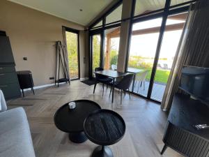 a living room with a tv and a table and chairs at Rijn Residentie in Alphen aan den Rijn +28 photos