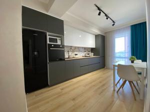 a kitchen with a black refrigerator and a table with a chair at New chisinau in Chişinău