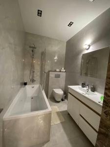 a bathroom with a tub and a toilet and a sink at New chisinau in Chişinău +100 photos