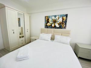 a bedroom with a white bed and a painting on the wall at New chisinau in Chişinău