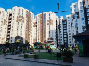 a park with a playground in front of tall buildings at New chisinau in Chişinău