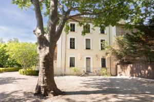 une grande maison blanche avec un arbre devant dans l'établissement La Villa Jaume, à Argelès-sur-Mer