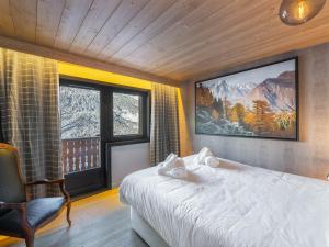 une chambre avec un lit et une télévision au mur dans l'établissement Chalet familial moderne à Méribel Village, terrasse sud avec jacuzzi, proche pistes et commerces - FR-1-566-56, à Les Allues