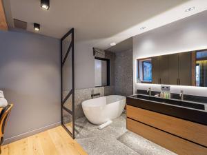 une salle de bains avec baignoire et lavabo dans l'établissement Chalet familial moderne à Méribel Village, terrasse sud avec jacuzzi, proche pistes et commerces - FR-1-566-56, à Les Allues