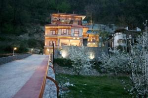 a large house sitting on top of a hill at night at Hotel Athina in Kato Loutraki