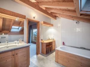 ein Badezimmer mit großer Badewanne und Waschbecken in der Unterkunft Chalet spacieux pour 14 personnes avec sauna et parking à Méribel - FR-1-566-65 in Les Allues