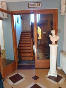 a entrance to a museum with a statue on a column at la thiberienne du Nord in Thiviers