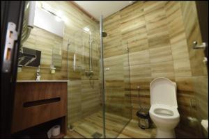 a bathroom with a toilet and a glass shower at Konak Koliba in Leskovac