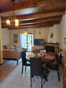 un salon avec une table à manger et un canapé dans l'établissement Horizon Nest Parnassos Villa Chalet!, à Eptalofos