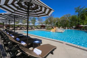 a swimming pool with lounge chairs and an umbrella at Nemacolin in Farmington