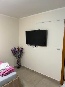 Una habitación con un televisor de pantalla plana en una pared. en Center Budget Rooms, en Kladovo