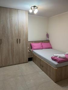 Un dormitorio con una cama grande y armarios de madera. en Center Budget Rooms, en Kladovo
