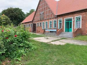 an old brick building with a green door and windows at Wohnung In Dreveskirchen Mit Kleinem Garten in Blowatz
