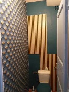 baño con aseo y pared de madera en La Résolue, en Millas