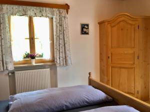 a bedroom with a bed and a window and a door at Haus Hinterseer in Schneizlreuth +11 photos