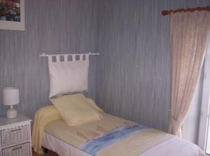 a small bedroom with a bed and a window at L Eucalyptus in Aumeville-Lestre