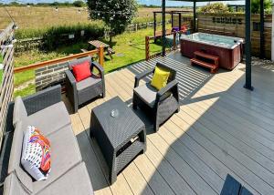 une terrasse avec des chaises et un bain à remous dans l'établissement Raywell Hall Country Lodges, à Skidby