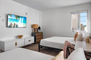 ein weißes Schlafzimmer mit zwei Betten und einem Tisch in der Unterkunft Luxuri Suites in Miami Beach + 67 Fotos