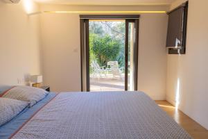 een slaapkamer met een bed en een glazen schuifdeur bij Évasion et Confort Aubagne in Aubagne +19 foto's