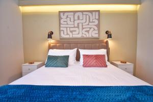 ein Schlafzimmer mit einem Bett mit zwei bunten Kissen in der Unterkunft Villa Sokratis Mountain View in Porti 