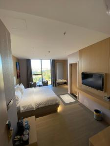 una habitación de hotel con cama y televisor de pantalla plana en Rek Holiday Hotel, en Erbil