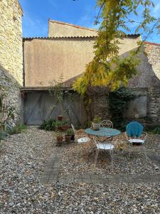 a patio with a table and chairs in a yard at Spacious Village House in Ginoles with Garden in Ginoles