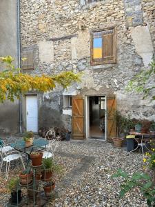 a stone building with a table and chairs in front of it at Spacious Village House in Ginoles with Garden in Ginoles