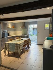 Una cocina con una mesa y sillas en una cocina. en Spacious Village House in Ginoles with Garden, en Ginoles