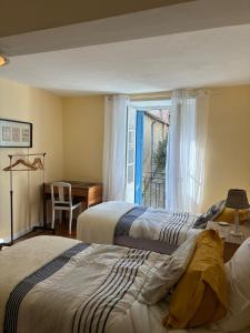 two beds in a room with a window at Spacious Village House in Ginoles with Garden in Ginoles +9 photos