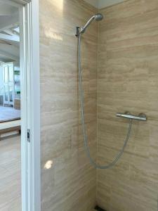 una ducha con cabezal de ducha en un baño en Holiday Home With Soul A Few Steps From The Water, en Martofte