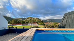 Whale Walk Apartment في هيرمانوس: مسبح وسطح خشبي وجبال في الخلف +8 صور