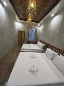 - une chambre avec 2 lits dotés de draps blancs et d'un lustre dans l'établissement Kawayan Hostel, à General Luna 26 autres photos