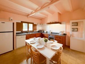 eine Küche mit einem Tisch mit Stühlen und einem Kühlschrank in der Unterkunft Blue House in Urtx