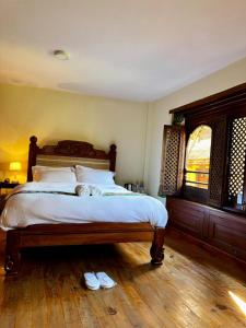 a bedroom with a bed with two slippers on the floor at Hotel Nutopia in Pātan +10 photos