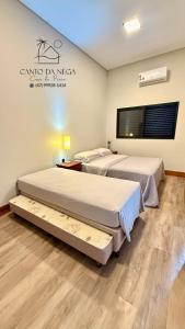 2 posti letto in una camera con un cartello sul muro di Canto da Nega - Seu canto na Praia! a Itapoa