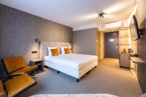a hotel room with a bed and a chair at Hotel Asteria in Venray +38 photos
