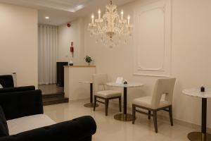 胡志明市The Writeriana de Lumière的客厅配有桌椅和吊灯。 更多26张照片